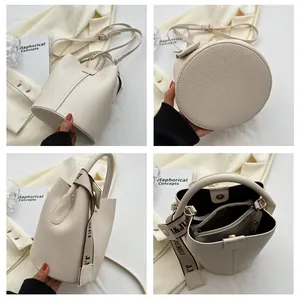 Détail du sac seau crème en cuir grainé avec pochette intérieure et poignée ruban