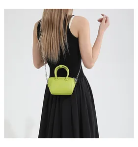 Rear view of a model wearing the mini lime green leather crossbody bag with a silver chain