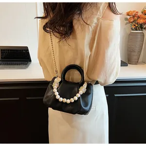 Détail du sac nuage noir plissé avec poignée en perles nacrées et chaîne en métal doré