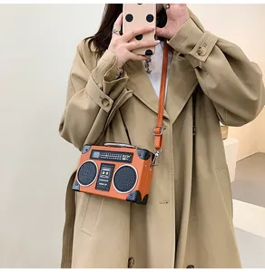 Macro detail of a creative retro radio shaped crossbody bag with orange finish