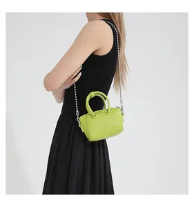 Close-up of mini lime green cross-body bag with litchi texture and silver chain strap