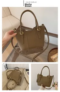 Close-up of mocha brown lychee leather bucket bag with golden hardware and circular handles