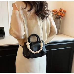 Détail du sac nuage plissé noir avec poignée en perles et bandoulière en chaîne