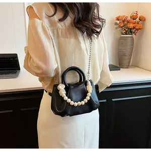 Détail du sac nuage plissé noir avec poignée en perles blanches et bandoulière chaîne