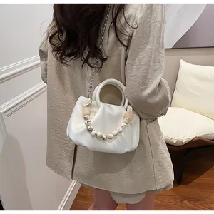 Détail du sac nuage blanc plissé avec poignée en perles décoratives et chaîne argentée