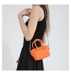 Detail of orange pebble leather mini Boston bag with silver ball chain strap