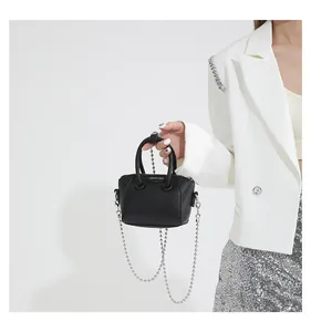 Close-up of black lychee grain mini handbag with silver chain and white fashion logo