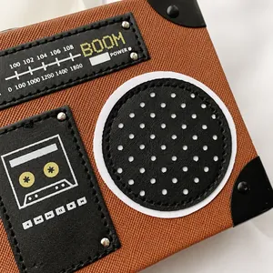 Dettaglio della borsa vintage a radio con pelle testurizzata e grafica retrò