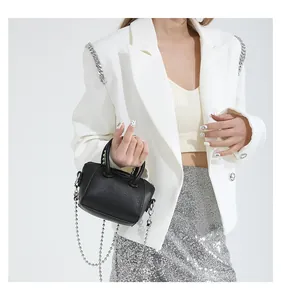 Detail of a mini black lychee leather bag with silver ball chain and top handle strap