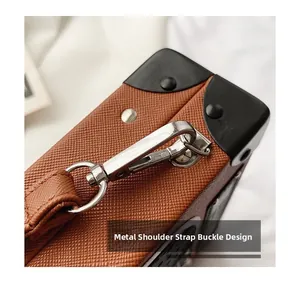 Detail of silver metal shoulder strap buckle on brown radio-shaped cross-body bag