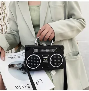 Detail of creative vintage radio shape shoulder bag with metallic handle and textured PU leather