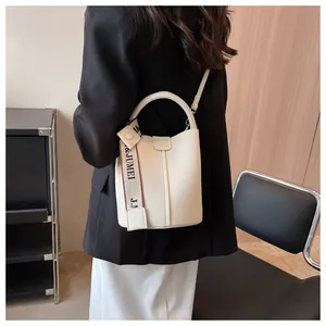 Sac seau beige chic en cuir litchi avec bandoulière logo et détail de poignée ronde