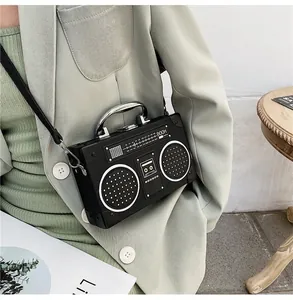 Detail view of radio shaped crossbody bag with metallic handle and boom text graphic