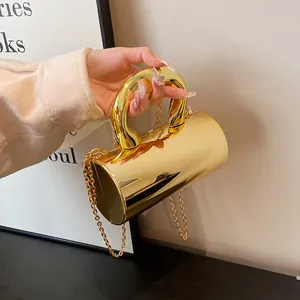 Minimalistische goldene zylindrische Abendtasche mit rundem Griff und goldener Kette