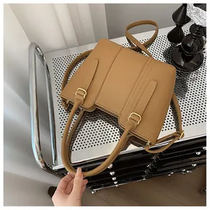 Detailed view of caramel pebble leather bucket bag with gold buckles and adjustable strap