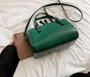 Comparación de tamaño del bolso Boston verde cocodrilo con un móvil para escala