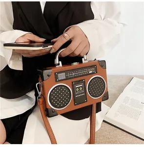 Detail of creative radio-shaped handbag in brown PU leather with silver handle and strap