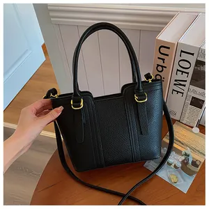 Close-up of black pebbled leather bucket bag with gold hardware and stitching details