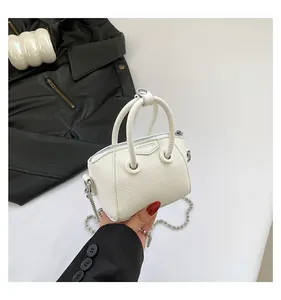 Detailed close-up of a mini white lychee leather Boston bag with silver chain strap