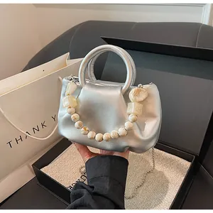 Détail du sac nuage argenté plissé avec poignée en perles marbrées dans son coffret
