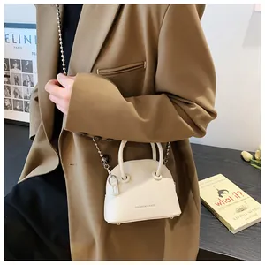 Detail of a white semicircular mini handbag with golden chain strap and fashion text