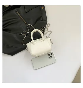 Micro mini white tote bag with silver bead chain shown next to a smartphone for scale