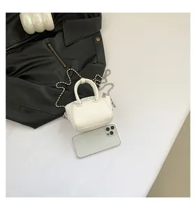 Detailed comparison showing the mini white pebble leather bag next to a smartphone