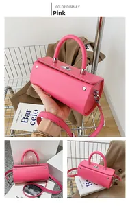 Detail view of pink leather cylinder bag with silver hardware and adjustable shoulder strap