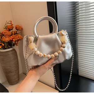 Détail du sac nuage plissé argenté avec poignée en perles de marbre et bandoulière chaîne