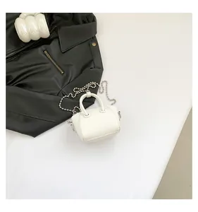 Detailed close-up of white pebble leather mini bag with silver bead chain strap and handle