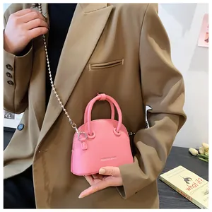 Detailed shot of pink pebble leather bag with silver bead chain and fashion logo