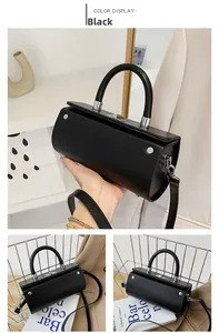 Detail view of a black leather cylinder bag with silver metal buckles and handles