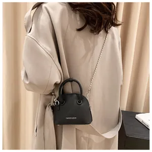 Rear view of a stylish black mini crossbody bag with a silver beaded chain strap.