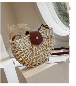 Détail du sac bandoulière en paille demi-lune avec rabat en cuir marron et bouton métallique