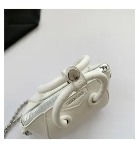 Close-up of white pebble leather mini bag with silver chain strap and fashion embossing