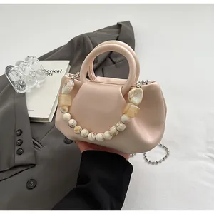 Détail du sac nuage froncé abricot avec poignée en perles marbre et chaîne argentée