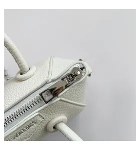 Close-up of white lychee leather texture and metallic zipper on the fashion handbag
