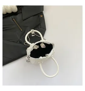 Top view of white pebble grain mini bag with silver bead chain and ring handles