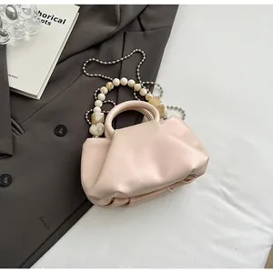 Détail du sac nuage plissé avec chaîne en perles et poignée ronde rigide chic