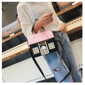 Detail of creative house-shaped crossbody bag with pink roof and black leather exterior