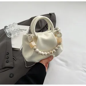 Détail du sac nuage plissé crème avec poignée en perles marbrées et bandoulière