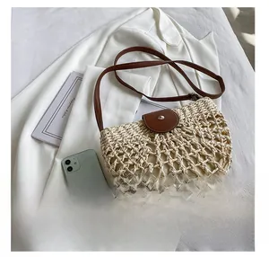 Détail du sac en paille crème avec rabat en cuir marron et fermoir magnétique argenté