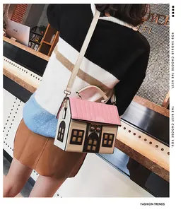 Unique house-shaped crossbody bag featuring a pink roof and cream-colored textured finish