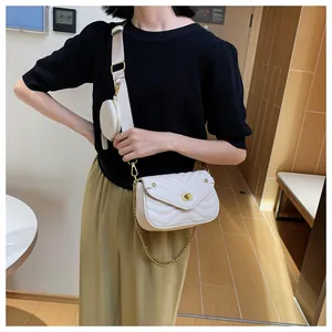 Détail du sac bandoulière matelassé crème avec chaîne dorée et petit porte-monnaie rond