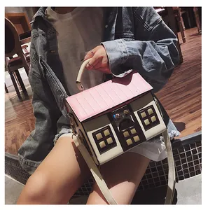 Creative house-shaped crossbody bag with pink roof and beige walls shown on model