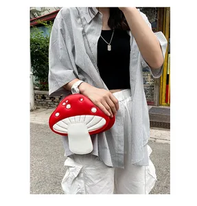 Detail of red and white mushroom crossbody bag showing 3D polka dots and silver chain strap