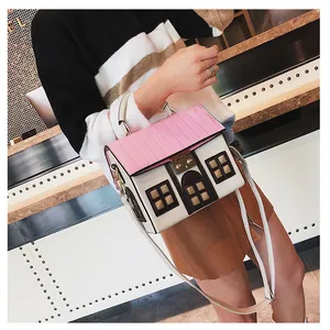 Detail of creative house-shaped crossbody bag with pink quilted roof and metal lock