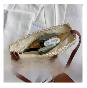 Détail intérieur d'un sac à bandoulière en paille montrant la capacité de rangement quotidien