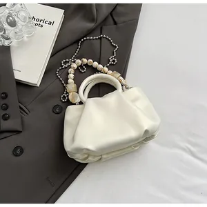 Détail du sac nuage plissé crème avec perles marbrées et chaîne à boules