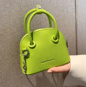 Neon green mini tote bag with lychee texture and silver bead chain shown held by hand